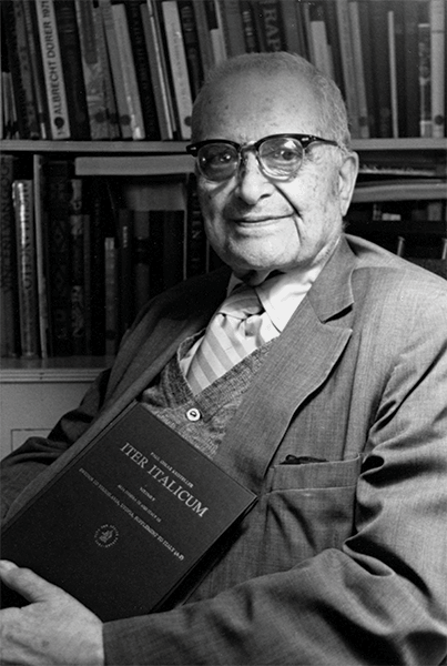 Rare Book and Manuscript Library, Columbia University. Photograph of Paul Oskar Kristeller holding the book Iter Italicum.