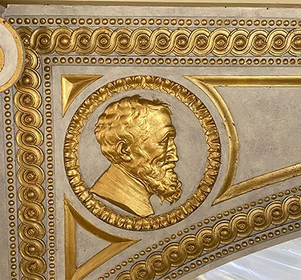 Gilded medallion portrait of Michelangelo atop the stage of the Casa Italiana's Teatro. 